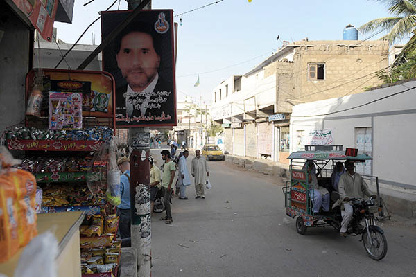 A poster of a Shia victim of a car bombing hangs outside a shop in Abbas Town. Rizwan Tabassum—AFP