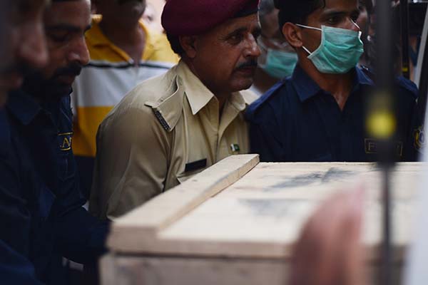 Rescuers transfer coffins from ambulances to an Islamabad hospital. Farooq Naeem—AFP
