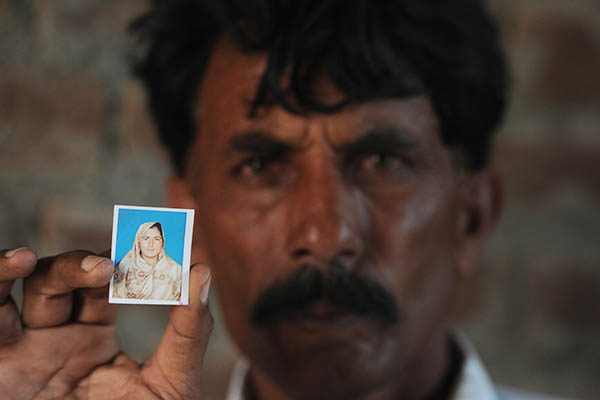Mohammad Iqbal holds a picture of his wife, Farzana. Aamir Qureshi—AFP