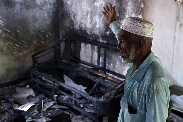 A Sri Lankan Muslim gestures toward his charred home in Aluthgama. Lakruwan Wanniarachchi—AFP