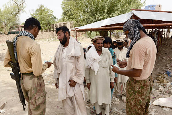Soldiers check documentation of IDPs in Bannu. A. Majeed—AFP